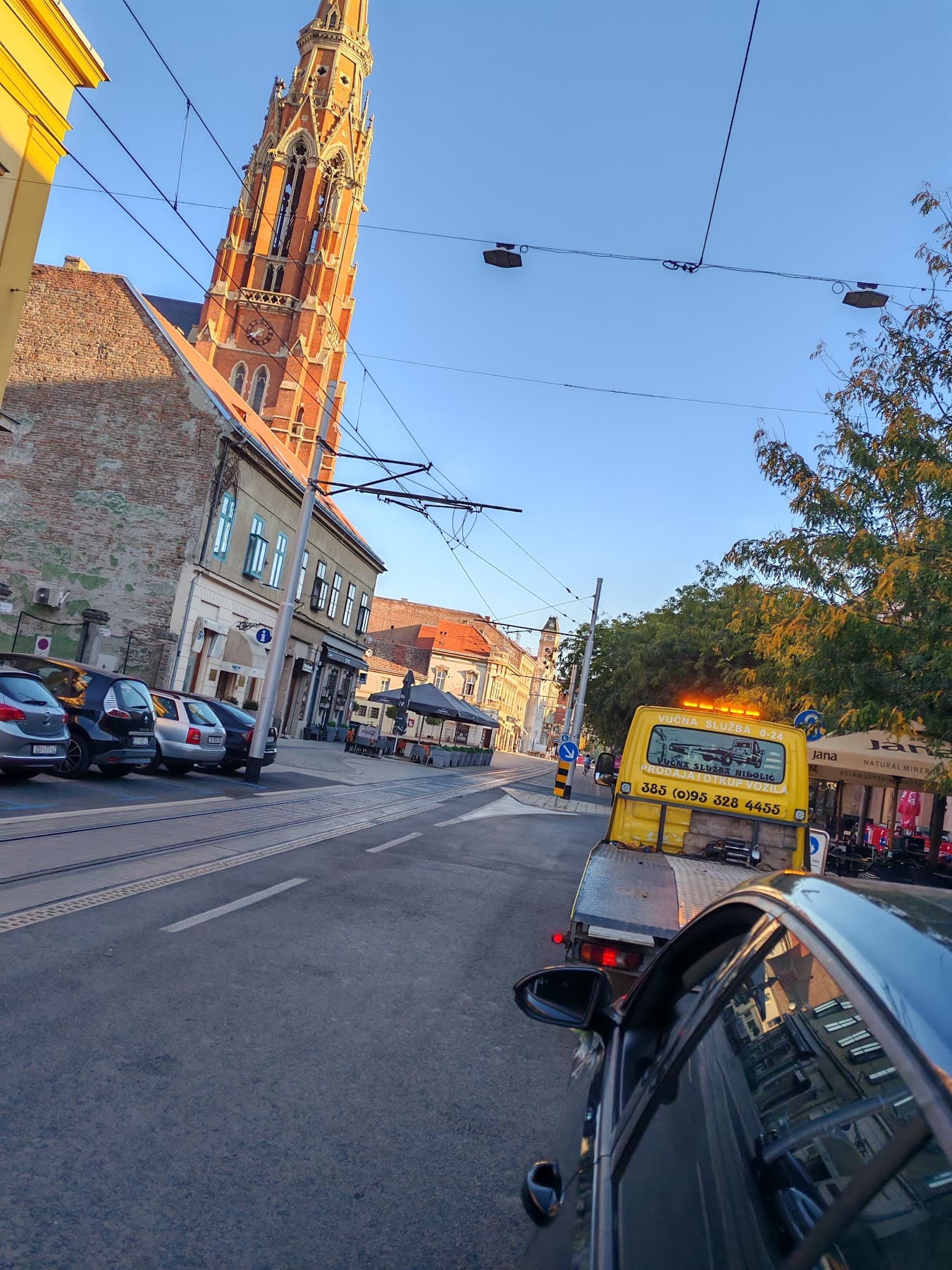 Tow truck driving through central Osijek at dusk