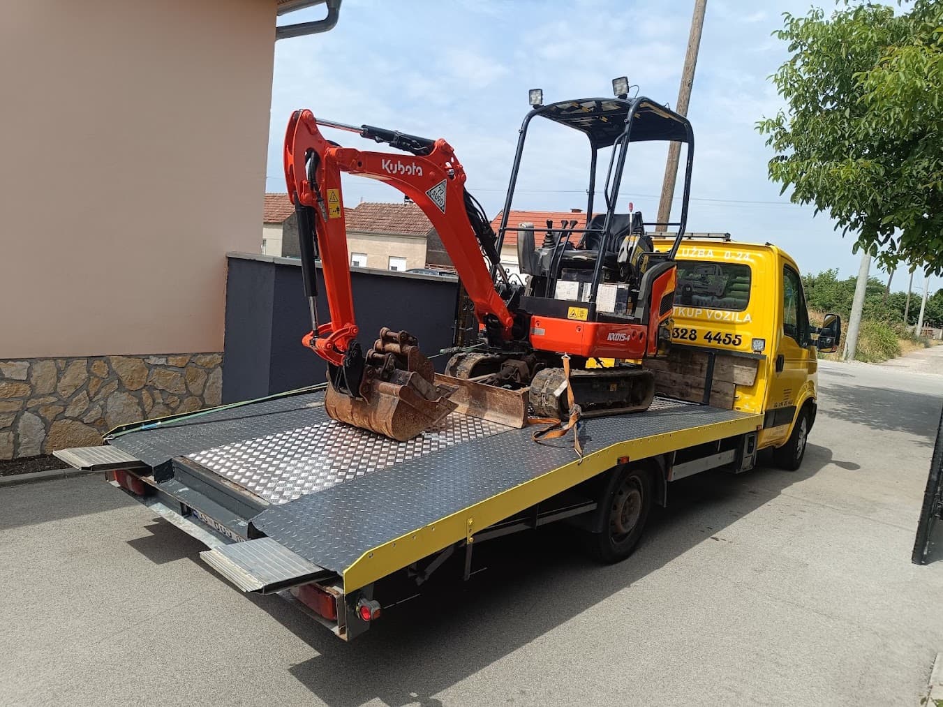 Orange Kubota mini excavator loaded on a flatbed